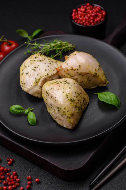 Lezzetli ızgara tavuk, tuzlu, baharatlı ve sebzeli, koyu beton arka planda.