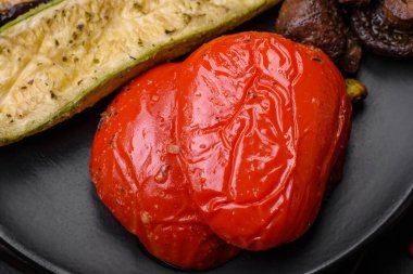 Lezzetli ızgara sebzeler kabak, patlıcan, biber ve mantarlı tuz, baharat ve otlar koyu beton arka planda.