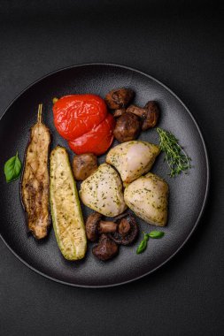 Lezzetli ızgara tavuk, tuzlu, baharatlı ve sebzeli, koyu beton arka planda.