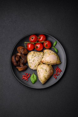 Lezzetli ızgara tavuk, tuzlu, baharatlı ve sebzeli, koyu beton arka planda.