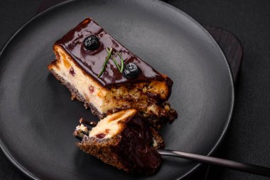 Koyu beton arka planda çikolatalı meyveli tatlı cheesecake.