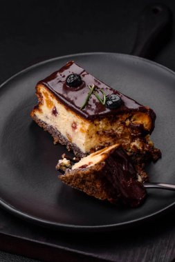Koyu beton arka planda çikolatalı meyveli tatlı cheesecake.
