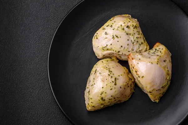 stock image Delicious juicy grilled chicken with salt, spices and herbs with vegetables on a dark concrete background