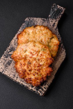 Lezzetli taze kızarmış tavuk eti pirzolası. Koyu beton zeminde tuz, baharat ve otlarla birlikte.