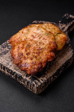 Lezzetli taze kızarmış tavuk eti pirzolası. Koyu beton zeminde tuz, baharat ve otlarla birlikte.