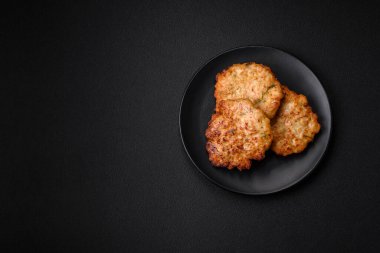 Lezzetli taze kızarmış tavuk eti pirzolası. Koyu beton zeminde tuz, baharat ve otlarla birlikte.