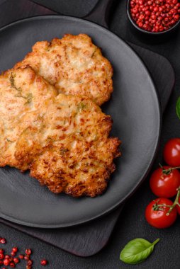 Lezzetli taze kızarmış tavuk eti pirzolası. Koyu beton zeminde tuz, baharat ve otlarla birlikte.