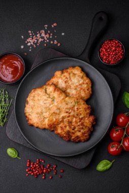 Lezzetli taze kızarmış tavuk eti pirzolası. Koyu beton zeminde tuz, baharat ve otlarla birlikte.