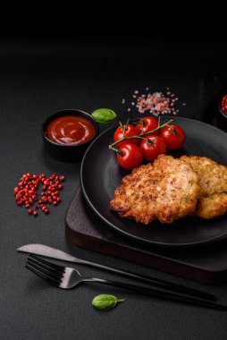 Lezzetli taze kızarmış tavuk eti pirzolası. Koyu beton zeminde tuz, baharat ve otlarla birlikte.