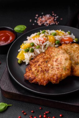 Lezzetli taze kızarmış tavuk eti pirzolası. Koyu beton zeminde tuz, baharat ve otlarla birlikte.