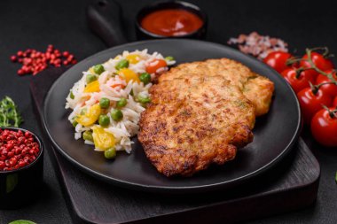 Lezzetli taze kızarmış tavuk eti pirzolası. Koyu beton zeminde tuz, baharat ve otlarla birlikte.