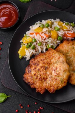 Lezzetli taze kızarmış tavuk eti pirzolası. Koyu beton zeminde tuz, baharat ve otlarla birlikte.