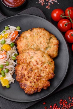 Lezzetli taze kızarmış tavuk eti pirzolası. Koyu beton zeminde tuz, baharat ve otlarla birlikte.