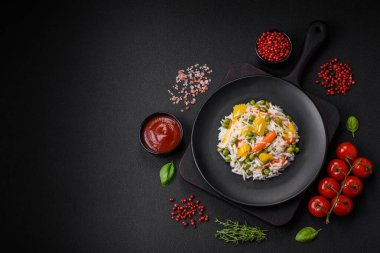 Lezzetli taze haşlanmış pirinç, sebzeli havuç, biber ve kuşkonmaz fasulyesi, koyu beton arka planda seramik bir tabakta.