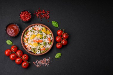 Lezzetli taze haşlanmış pirinç, sebzeli havuç, biber ve kuşkonmaz fasulyesi, koyu beton arka planda seramik bir tabakta.