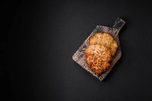 Lezzetli taze kızarmış tavuk eti pirzolası. Koyu beton zeminde tuz, baharat ve otlarla birlikte.