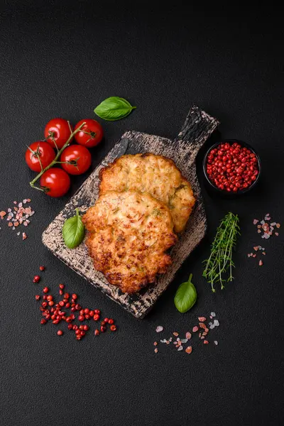 Lezzetli taze kızarmış tavuk eti pirzolası. Koyu beton zeminde tuz, baharat ve otlarla birlikte.