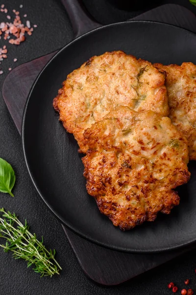 stock image Delicious fresh fried minced chicken meat cutlets with salt, spices and herbs on a dark concrete background