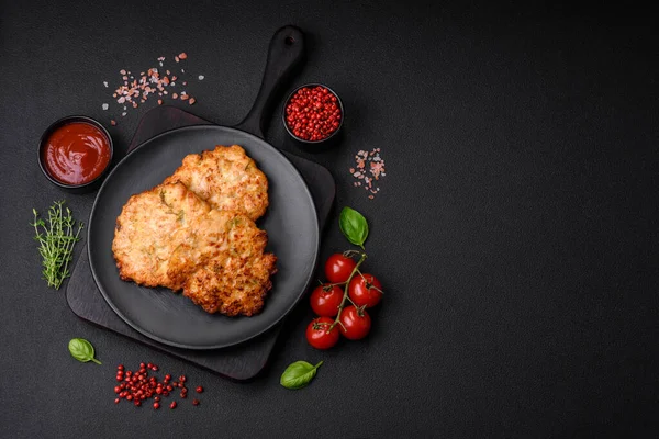 Lezzetli taze kızarmış tavuk eti pirzolası. Koyu beton zeminde tuz, baharat ve otlarla birlikte.