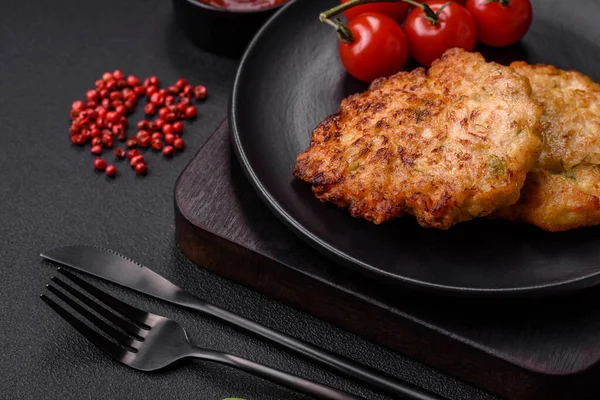 Lezzetli taze kızarmış tavuk eti pirzolası. Koyu beton zeminde tuz, baharat ve otlarla birlikte.