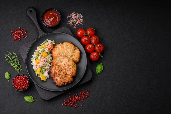 Lezzetli taze kızarmış tavuk eti pirzolası. Koyu beton zeminde tuz, baharat ve otlarla birlikte.