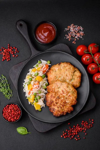 Lezzetli taze kızarmış tavuk eti pirzolası. Koyu beton zeminde tuz, baharat ve otlarla birlikte.