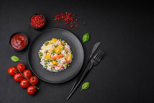 Lezzetli taze haşlanmış pirinç, sebzeli havuç, biber ve kuşkonmaz fasulyesi, koyu beton arka planda seramik bir tabakta.