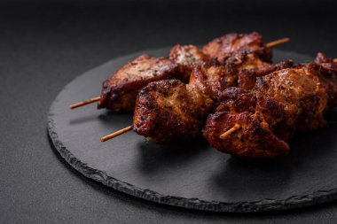 Lezzetli ızgara tavuk, hindi ya da domuz şişi, tuzlu, baharatlı ve otlu, koyu beton bir arka planda.