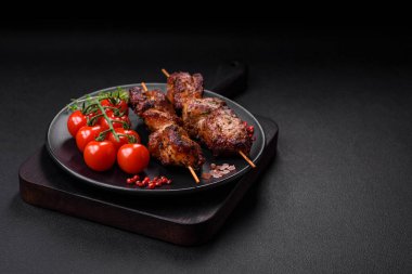 Lezzetli ızgara tavuk, hindi ya da domuz şişi, tuzlu, baharatlı ve otlu, koyu beton bir arka planda.