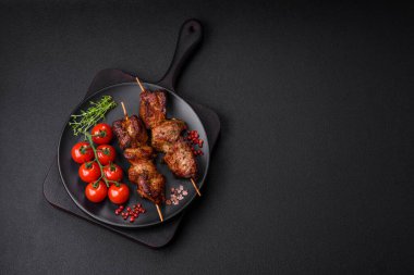 Lezzetli ızgara tavuk, hindi ya da domuz şişi, tuzlu, baharatlı ve otlu, koyu beton bir arka planda.