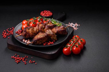 Lezzetli ızgara tavuk, hindi ya da domuz şişi, tuzlu, baharatlı ve otlu, koyu beton bir arka planda.