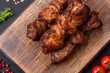 Lezzetli ızgara tavuk, hindi ya da domuz şişi, tuzlu, baharatlı ve otlu, koyu beton bir arka planda.