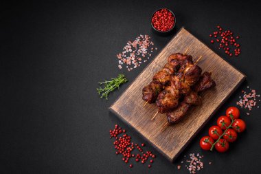 Lezzetli ızgara tavuk, hindi ya da domuz şişi, tuzlu, baharatlı ve otlu, koyu beton bir arka planda.