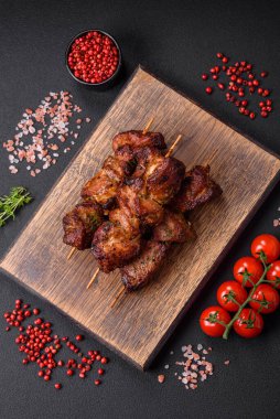 Lezzetli ızgara tavuk, hindi ya da domuz şişi, tuzlu, baharatlı ve otlu, koyu beton bir arka planda.