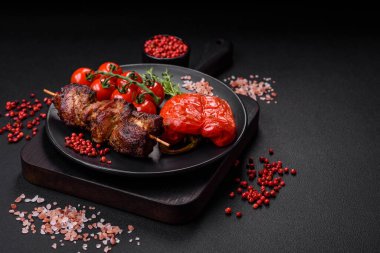 Lezzetli ızgara tavuk, hindi ya da domuz şişi, tuzlu, baharatlı ve otlu, koyu beton bir arka planda.