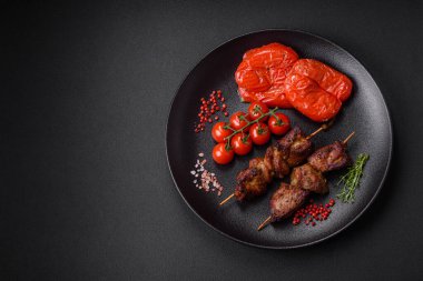 Lezzetli ızgara tavuk, hindi ya da domuz şişi, tuzlu, baharatlı ve otlu, koyu beton bir arka planda.