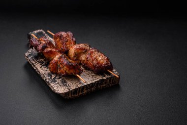Lezzetli ızgara tavuk, hindi ya da domuz şişi, tuzlu, baharatlı ve otlu, koyu beton bir arka planda.
