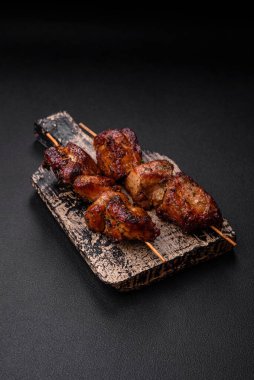 Lezzetli ızgara tavuk, hindi ya da domuz şişi, tuzlu, baharatlı ve otlu, koyu beton bir arka planda.