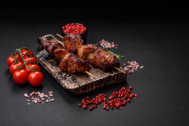 Lezzetli ızgara tavuk, hindi ya da domuz şişi, tuzlu, baharatlı ve otlu, koyu beton bir arka planda.