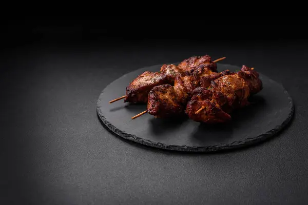 Lezzetli ızgara tavuk, hindi ya da domuz şişi, tuzlu, baharatlı ve otlu, koyu beton bir arka planda.