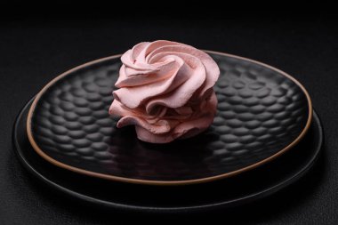 Koyu beton bir arka planda leziz, renkli bir marşmelov. Yemek masası için sağlıklı tatlılar.