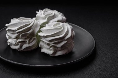 Koyu beton bir arka planda leziz, renkli bir marşmelov. Yemek masası için sağlıklı tatlılar.