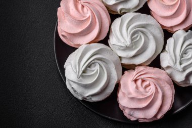 Koyu beton bir arka planda çok renkli tatlı marşmelov. Yemek masası için sağlıklı tatlılar.