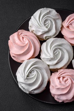 Koyu beton bir arka planda çok renkli tatlı marşmelov. Yemek masası için sağlıklı tatlılar.