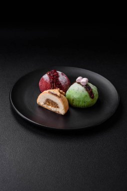 Lezzetli renkli mochi tatlılar ya da pirinç hamurlu dondurma ve koyu beton kaplama malzemeler.