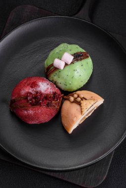 Lezzetli renkli mochi tatlılar ya da pirinç hamurlu dondurma ve koyu beton kaplama malzemeler.