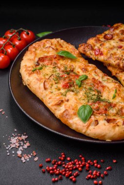 Lezzetli fırın peynirli, domatesli, sosisli, tuzlu ve baharatlı taze ekmek pizzası.