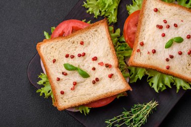 Lezzetli sandviç, tost, jambon, domates, peynir ve tuzlu, baharatlı ve çimento kaplı marul.