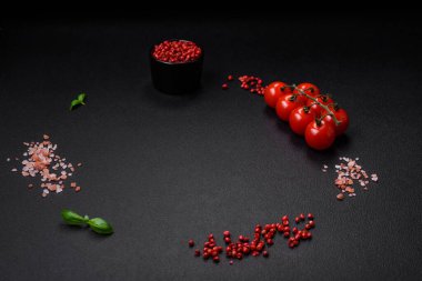 Koyu beton zeminde domates, tuz, baharat ve otlar pişirmek için gerekli malzemeler.