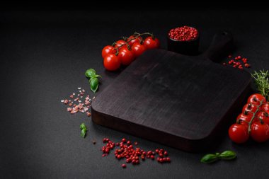 Koyu beton zeminde domates, tuz, baharat ve otlar pişirmek için gerekli malzemeler.